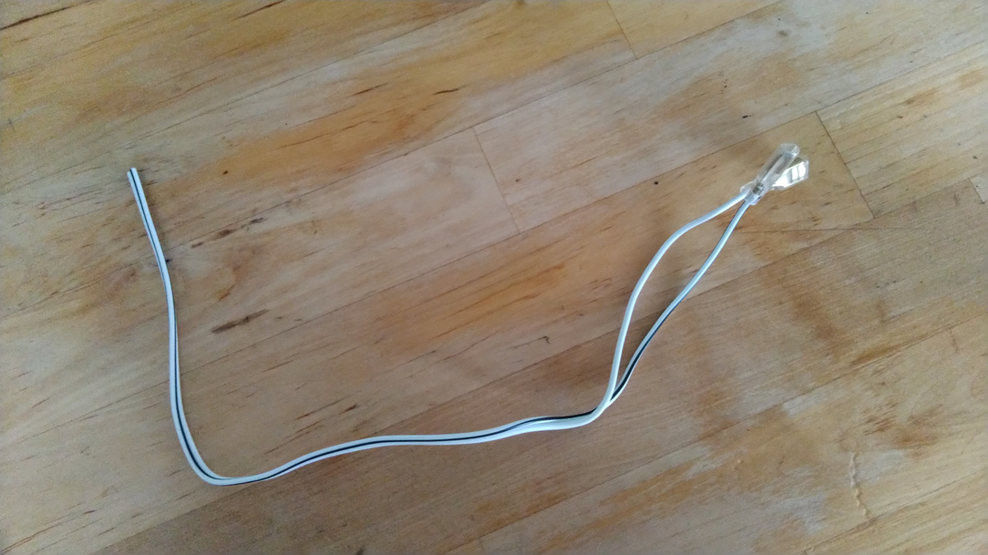 deux cables collé ensemble, blanc, l'un avec un liseré noir. Cosses au bout pour branchement sur une enceinte