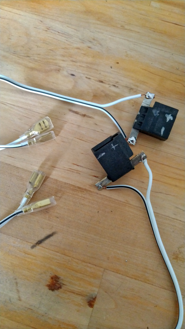 adaptateur entier. Les prises noires soudées aux fils avec cosses. Un symbole plusse et moins pour repere.