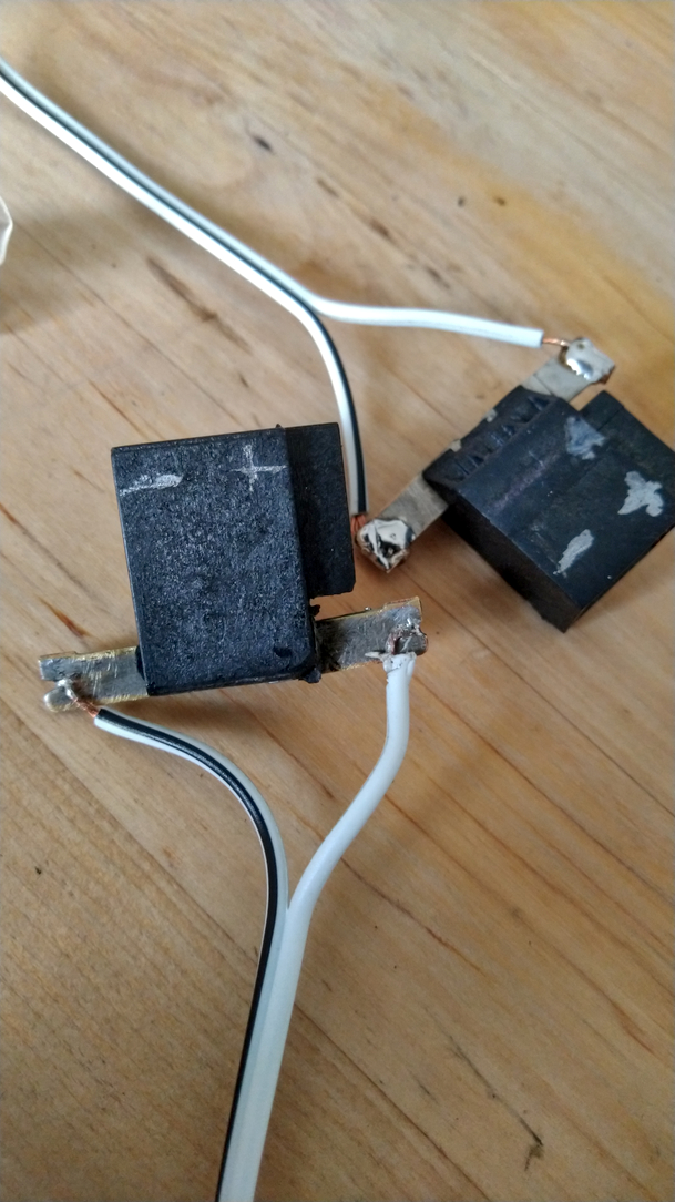 2 prises noires avec indicateur plusse et moins. Pour enceinte de voiture. On voit bien les pattes et les soudures des fils