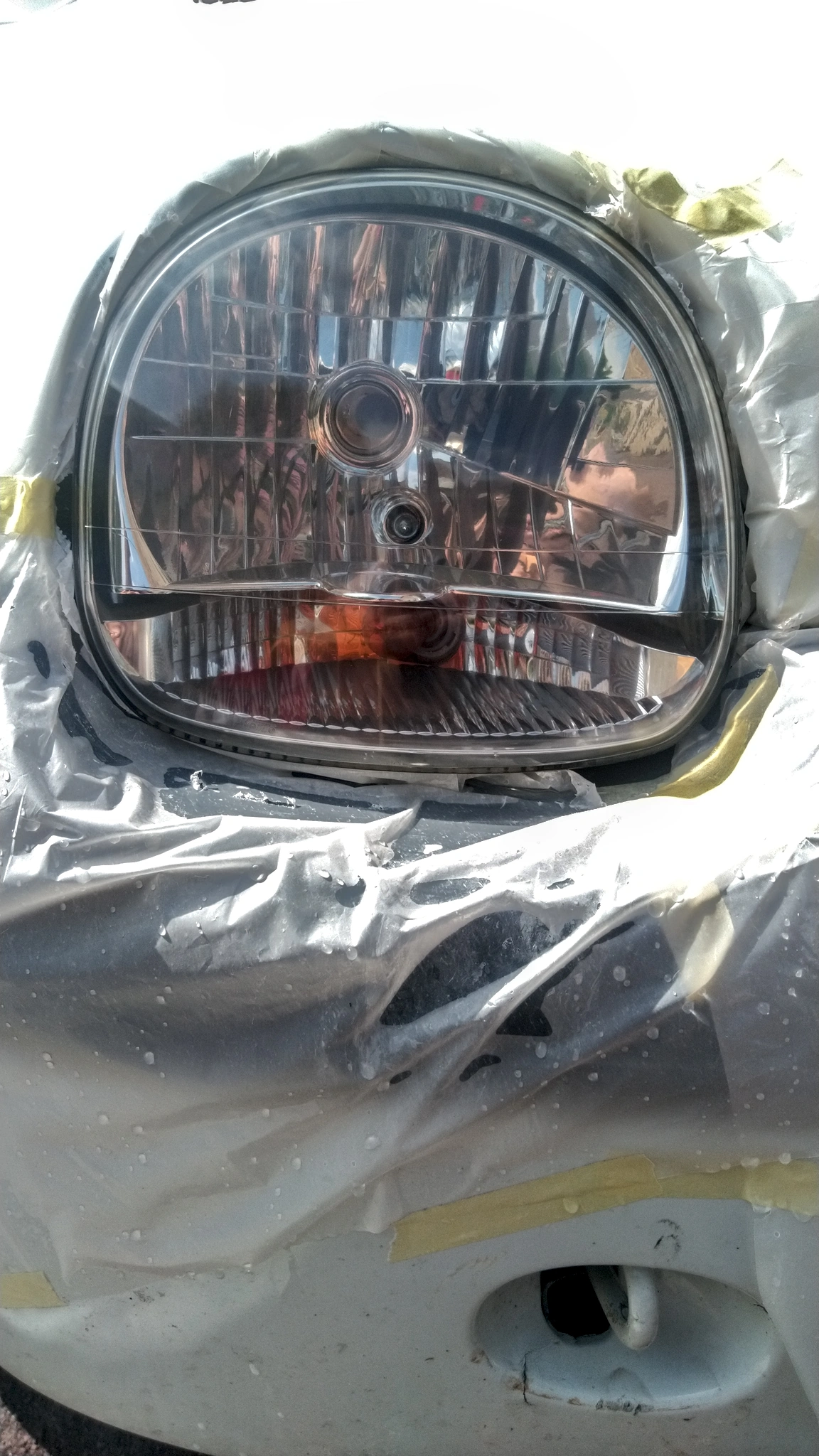 Détail du phare droit poncé et poli. Il est bien transparent et brillant. On ne distingue plus aucune trace de patine